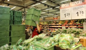 Katja Henriksson nostelee Yli-Nikulan salaatteja myyntiin.